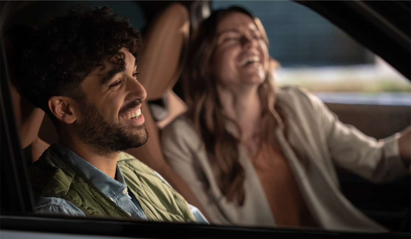homme et femme souriants dans leur voiture